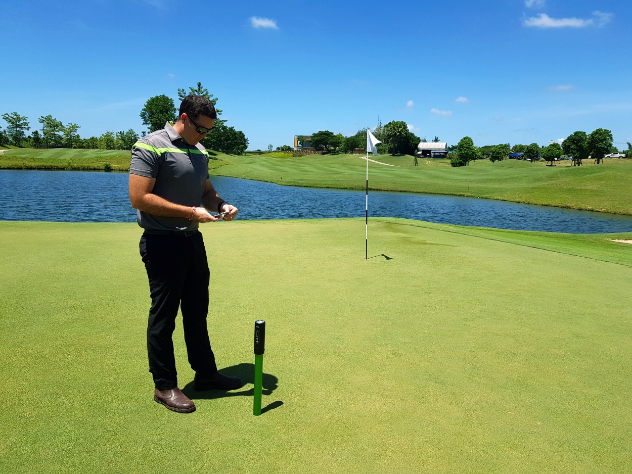 Taking soil moisture readings on the green using the Pogo moisture probe device