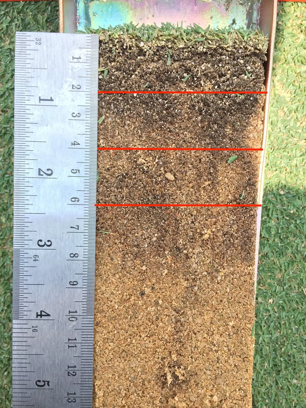 A golf green soil profile marked with sections for om246 testing.