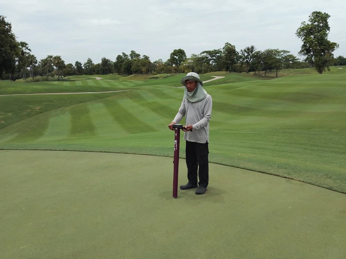 Checking the soil moisture of a golf green with a TDR moisture probe.