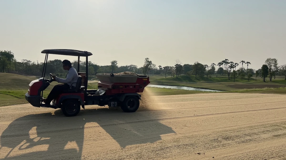 Sand topdressing of a putting green with a belt and brush style topdresser